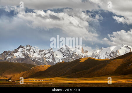 Die schöne Landschaft der weißen Gipfel Berge und Jurtencamp in das Tal in der Nähe von Kel Suu See in der naryn Region, Kirgisistan Stockfoto