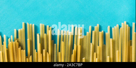 Rohe Spaghetti Pasta auf blauem Hintergrund. Panorama Ansicht Stockfoto