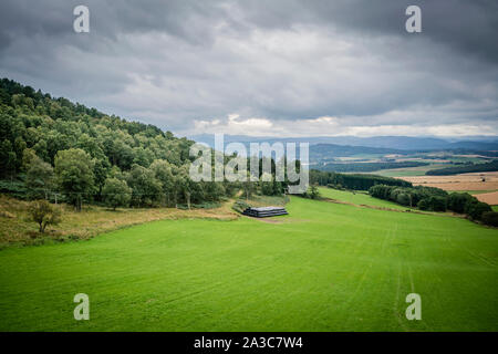 Schönen Hügeln und Ackerland im Queens Anzeigen in der Nähe von tarland in Aberdeenshire unter einem Moody sky Stockfoto