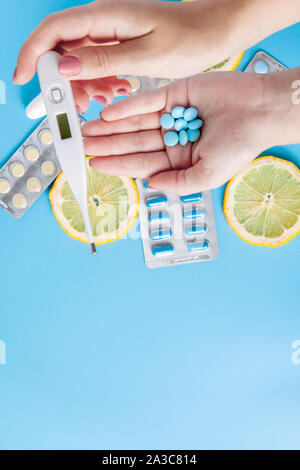 Medikamente, Pillen, Thermometer, traditionelle Medizin für die Behandlung von Erkältungen, Grippe, Wärme auf einem blauen Hintergrund. Aufrechterhaltung der Immunität. Saisonale Krankheiten. Stockfoto