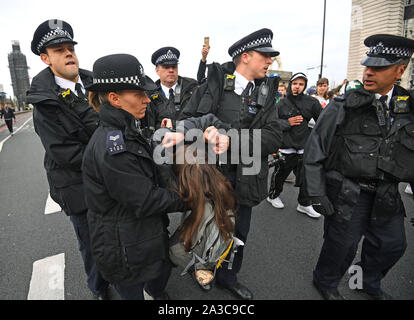 Eine Demonstrantin auf die Westminster Bridge, während ein Aussterben Rebellion (XR) Protest in Westminster, London festgenommen. Stockfoto