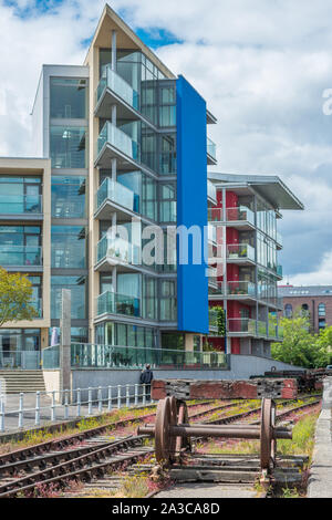 Moderner Appartementkomplex gegenüber Wapping Eisenbahn Wharf in Harbourside mit Gleisen im Vordergrund. Bristol. Avon. England. UK. Stockfoto