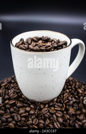 Weißer Becher Kaffee Bohnen auf Kaffeebohnen Stockfoto
