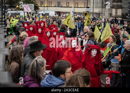 Das Aussterben Rebellion' Red Rebel Brigade' melden Sie den Klimawandel Aktivisten auf der Lambeth Brücke ihre Marke Blut rot Outfits tragen. London, Großbritannien. Stockfoto
