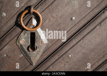 Alte verrostete Schlüsselloch und kleinen Ring auf hölzernen Tür, Nahaufnahme Stockfoto