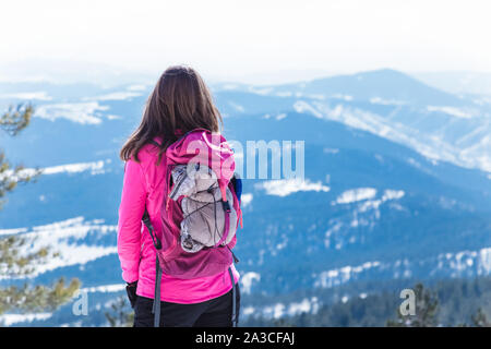 Ansicht der Rückseite des weiblichen Blick auf verschneite Berge. Stockfoto