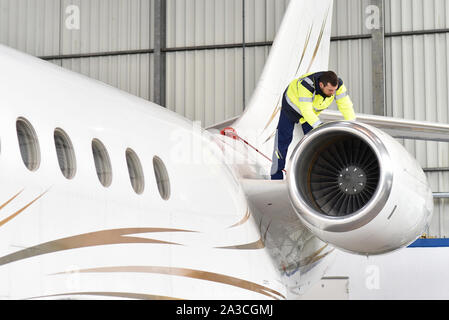 Fluggerätmechaniker inspiziert und überprüft die Technologie eines Jet in einem Hangar am Flughafen Stockfoto