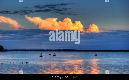 Verankerte Segelboote mit schönen Wolken bei Sonnenuntergang Stockfoto