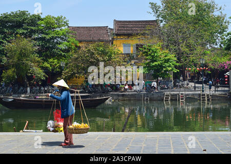 HOI AN, VIETNAM - 5. April 2019: vietnamesische Frau Früchte verkaufen auf dem bunten Straßen der Altstadt von Hoi An, Vietnam Stockfoto