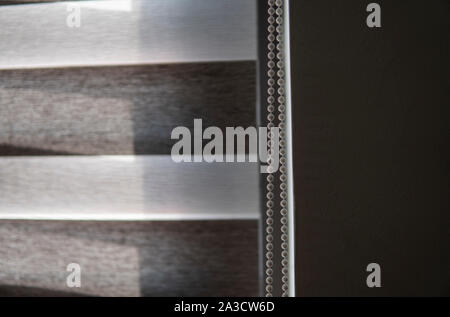 Details von braunem Stoff Rollos an den Kunststoff Fenster mit Holz Textur im Wohnzimmer. Stockfoto