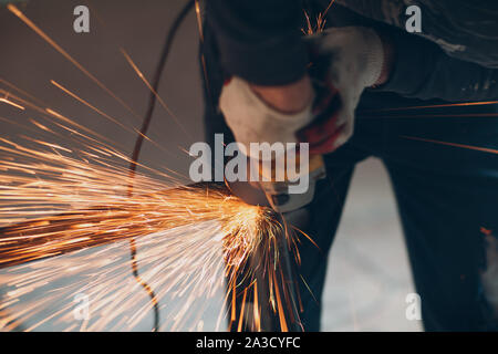 Handwerker Sägen von Metall mit dem Winkelschleifer sah in der Werkstatt Stockfoto