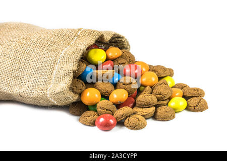 Bunte pepernoten behandelt in Jute Tasche auf weißem Hintergrund für die jährliche Sinterklaas holiday Event in den Niederlanden am 5. Dezember Stockfoto