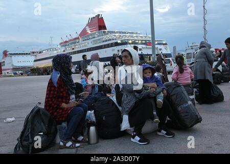 Piräus, Griechenland. 7 Okt, 2019. Flüchtlinge und Migranten warten mit ihren Habseligkeiten nach dem Aussteigen aus einer Fähre in den Hafen von Piräus, in der Nähe von Athen. Migranten und Flüchtlinge kommen in den Hafen von Piräus der von der Insel Lesbos als Behörden haben beschleunigte Anstrengungen zu Tausenden von Migranten gelten als gefährdet, von den überfüllten Moria camp Camps auf dem Festland bewegen. (Bild: © aristidis VafeiadakisZUMA Draht) Stockfoto