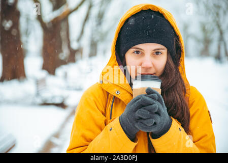 Frau trinkt Kaffee draußen im Park portrait. Trinken gehen. Winter warm up Stockfoto