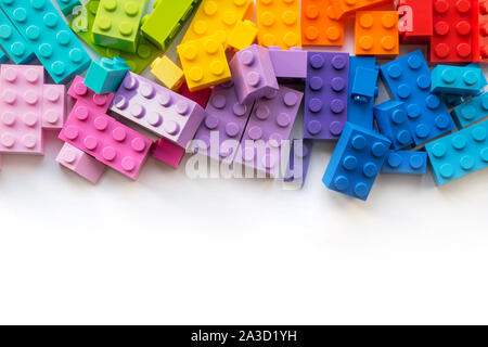 Viele bunte Plastick Konstruktor Blöcke auf weißem Hintergrund. Beliebte Spielzeug. Copyspace Stockfoto