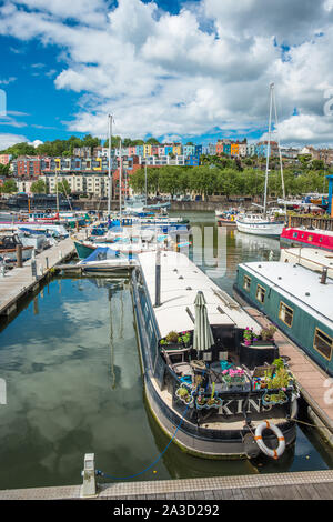 Lange Boote an der Bristol Marina mit bunten Häusern von hotwells nach hinten. Bristol, Avon, England, UK. Stockfoto