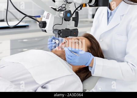 Junge männliche Patienten, professionelle zahnmedizinische Behandlung Stockfoto