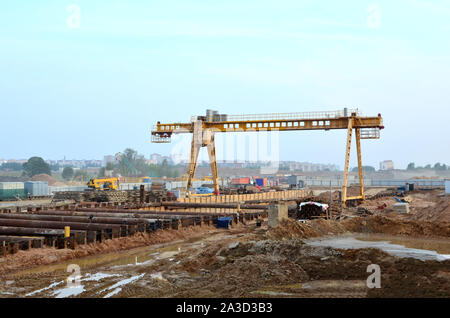 Gelbe gantry Brücke Kran auf den offenen Bereich, in der Nähe der U-Bahn Bau Projekt. Сut-und-Bau der U-Bahn Station. Baugrube der 'Aerodromn Stockfoto