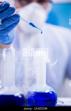 Closeup Schuß des blauen Lösung Drop aus einer Pipette durch einen Wissenschaftler in einem Forschungslabor eingesetzt. Stockfoto