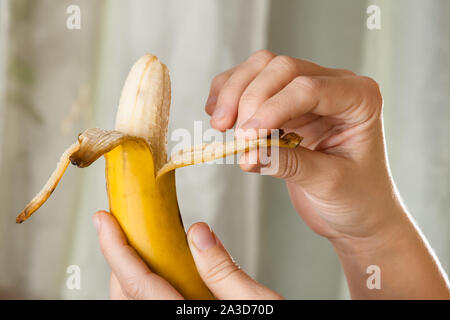 Hände peeling reife, gelbe Banane, Nahaufnahme Stockfoto