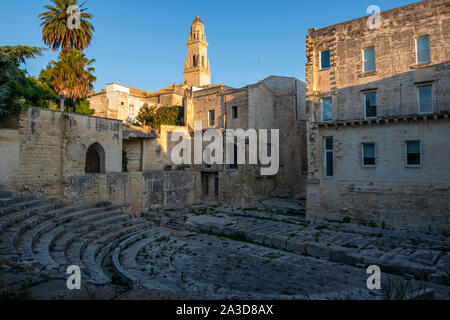 Am frühen Morgen die Sonne auf den Glockenturm der Kathedrale von Lecce mit römischen Theater (Teatro Romano) im Vordergrund - Lecce, Apulien (Puglia) im südlichen Italien Stockfoto