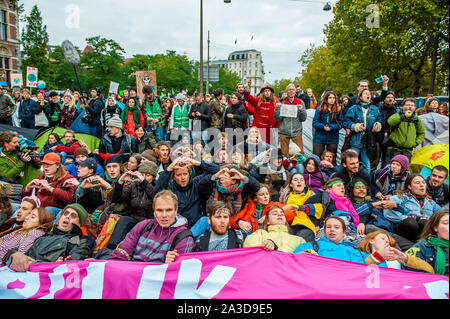 Tausende Aktivisten halten ein Banner und Plakate während des Protestes gesehen. für 2 Wochen, Aussterben Rebellion und verwandter Bewegungen in den großen Städten auf der ganzen Welt sammeln und weiterhin rebellieren gegen die Regierungen der Welt für ihre kriminellen Untätigkeit auf das Klima und die ökologische Krise zu. XR Klima Aktivisten in Amsterdam werden eine große Blockade über mehrere Tage auf der Museumbrug zu organisieren, vor dem Rijksmuseum. Von früh am Morgen, Hunderte von XR Aktivisten auf der Brücke, wo es eine sichtbare Polizeipräsenz. Die Umweltorganisation ausgestorben Stockfoto