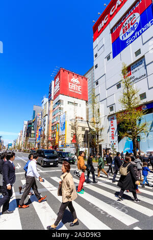 Tokio, Akihabara. Blick entlang der Straße von elektronischen und Spiele Stores, mit Menschen in den Vordergrund mit einem Zebrastreifen außerhalb Bic Camera Store. Tagfahrlicht Stockfoto