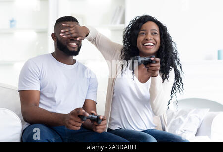 Tausendjährige paar Spielen von Videospielen auf der Couch zu Hause sitzen. Stockfoto