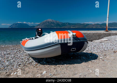 Helle, blaue Meer mit Bergen und einer Brücke im Hintergrund und Wind thront auf einem Hügel. Stockfoto