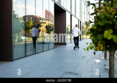 Junge und casual business Mann, Elektroroller in der Stadt Stockfoto