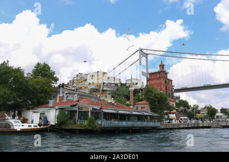 Fischrestaurants am Wasser, traditionelle Häuser mit Meerblick und Borusan Contemporary (Perili Kosk Mansion) am Bosporus an einem teilweise bewölkten Tag Stockfoto