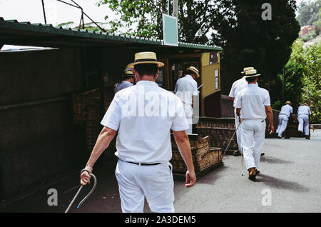 Weidenkorb Schlitten Treiber, Carreiros do Monte in Monte, Madeira, Portugal. Traditionelle Transportmittel zwischen Monte und Funchal, heute eine touristische Attraktion. Typische Strohhüte, weiße Kleidung. Stockfoto