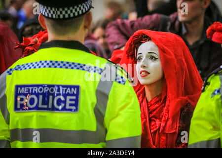 London, UK, 07. Okt 2019. Aussterben Rebellion Aktivisten aus der Gruppe der "Roten Brigaden", mit über 100 Teilnehmern, konfrontieren die Polizei in Millbank in Westminster, langsam entlang der Linie und direkt auf Offiziere, einen nach dem anderen. Credit: Imageplotter/Alamy leben Nachrichten Stockfoto