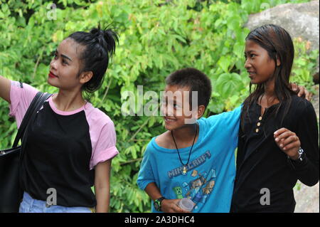 Eine verschwitzte gemischten Rennen 9 Jahre alten Jungen der Dschungel an einem heißen Tag mit zwei Roten Khmer Mädchen, Provinz Kampong Chhnang, Kambodscha untersucht. © kraig Lieb Stockfoto
