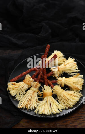 Hexen Besen der suluguni geräucherter Käse und Salami. Ursprüngliche Idee Halloween Snack. Stockfoto