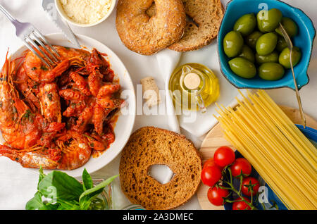 Traditionelle italienische Mittag- oder Abendessen. Geschmorter Tintenfisch und Garnelen in Tomatensauce. Meeresfrüchte Konzept, Ansicht von oben Stockfoto