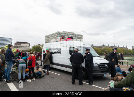 7 Oct 2019 - London, UK. Aussterben Rebellion Demonstranten und Polizei sammeln sich um eine Enterprise van, wie sie die Westminster Bridge blockieren. Stockfoto