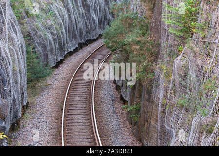 Rock schneiden durch Safety Netting durch Duncraig Station auf dem Inverness nach Kyle von lochalsh ScotRail Linie geschützt. In der Nähe von Plockton, Lochalsh, IV52 8TZ Stockfoto