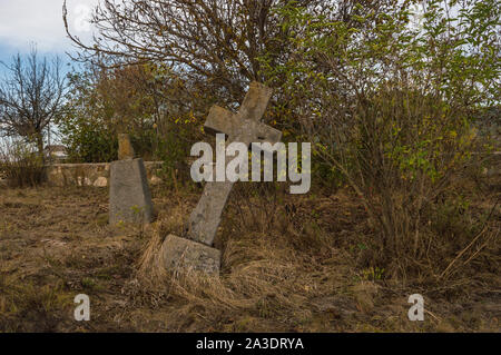 Alte Steinkreuz Grabsteinen auf verlassenen Friedhof Stockfoto