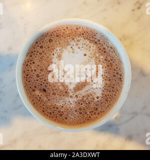 Heiße Schokolade (Latte) Kunst in Form einer weißen Blume. Stockfoto