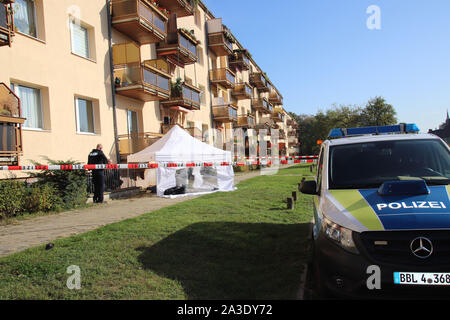 07. Oktober 2019, Frankfurt/Oder: Polizisten Line up an einem Haus, in dem zwei tote Männer gefunden wurden. Totschlag ist die Untersuchung. Eine 52-Jährige aus dem vierten Stock eines Wohnhauses Montag morgen früh gefallen war, sagte eine Sprecherin der Brandenburger Control Center an diesem Abend. Rettungskräfte versuchten, ihn wieder zu beleben. Es wird davon ausgegangen, dass Er starb infolge der Fallen, so die Sprecherin. Der Vater der Mann, ein 83-jähriger Senior, wurde tot in der Wohnung im Haus gefunden. Foto: Jan-Henrik Hnida/MOZ/dpa Stockfoto