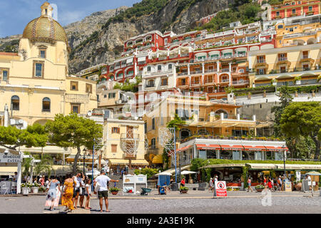 POSITANO, ITALIEN - AUGUST 2019: die Menschen an der Küste von Positano. Es ist von bunten Gebäude am steilen Hang übersehen. Stockfoto