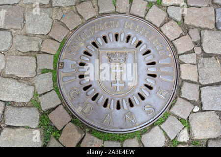 Danzig, Pommern, Polen - 19. Juni 2019: der Mann, der die Bohrung der Abdeckung mit dem Wappen der polnischen Stadt Danzig - Polen. Stockfoto