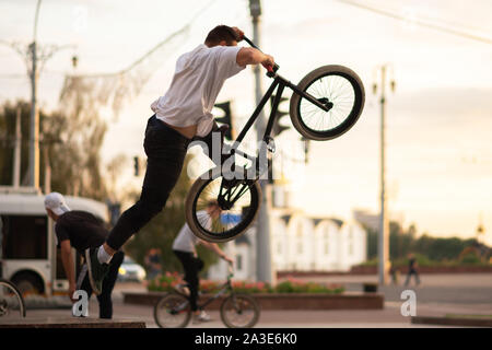 Der Kerl, ein Trick, springt aus dem BMX, von der Brüstung. Stockfoto