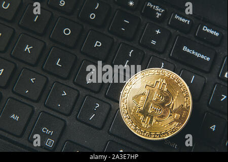 Bitcoin Münze auf moderne schwarze notebook tastatur platziert. Nahaufnahme foto Bitcoin, virtuellen Wert, Crypto digitales Geld. Stock Trading durch int Stockfoto