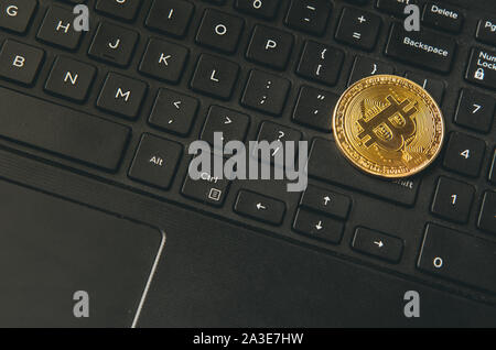 Bitcoin Münze auf moderne schwarze notebook tastatur platziert. Nahaufnahme foto Bitcoin, virtuellen Wert, Crypto digitales Geld. Stock Trading durch int Stockfoto