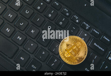 Bitcoin Münze auf moderne schwarze notebook tastatur platziert. Nahaufnahme foto Bitcoin, virtuellen Wert, Crypto digitales Geld. Stock Trading durch int Stockfoto