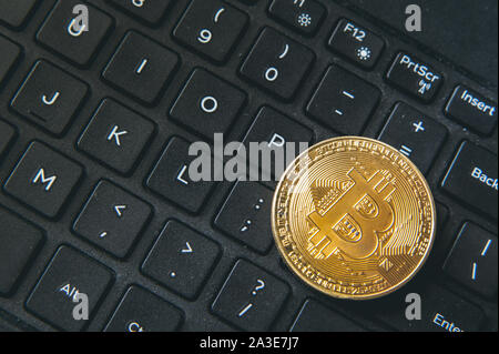 Bitcoin Münze auf moderne schwarze notebook tastatur platziert. Nahaufnahme foto Bitcoin, virtuellen Wert, Crypto digitales Geld. Stock Trading durch int Stockfoto