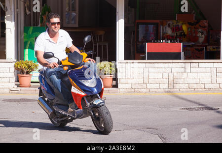 Motorradfahrer auf der griechischen Insel Korfu, Motorräder und Motorroller ohne Sturzhelme gegen das Gesetz Stockfoto