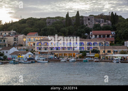 Nächtliche Abend lowlight Szene rund um den Hafen und das Meer in der Griechischen Ferienort Kassiopi auf der Insel Korfu in Griechenland mit Booten Stockfoto